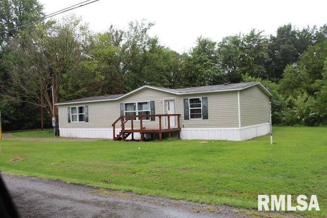 manufactured / mobile home featuring a wooden deck and a front lawn