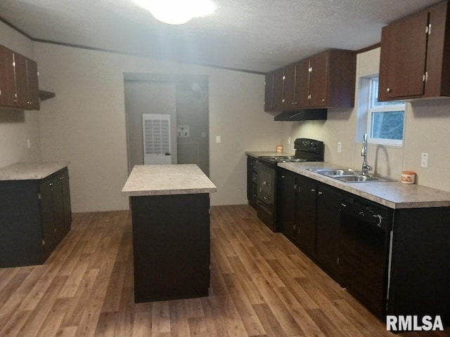 kitchen with light hardwood / wood-style floors, a center island, black appliances, and sink