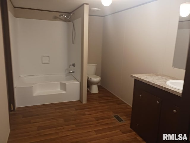 full bathroom featuring toilet, vanity, wood-type flooring, and washtub / shower combination