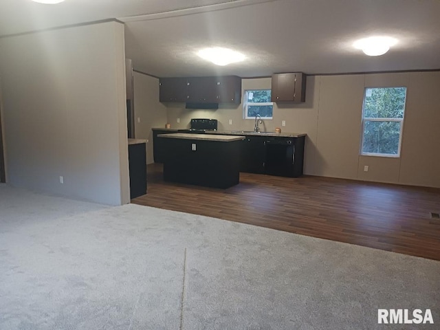 kitchen featuring dark wood-type flooring, a healthy amount of sunlight, sink, and a kitchen island