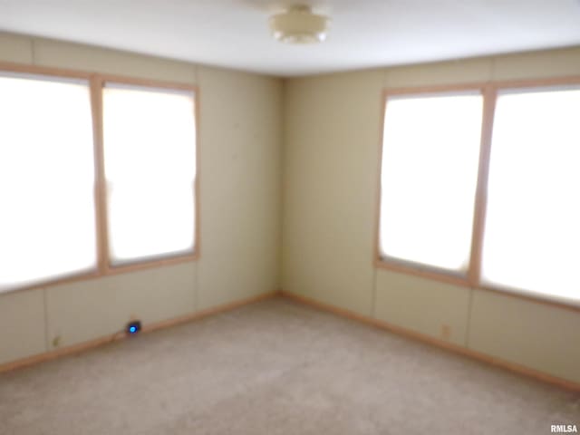 empty room featuring light colored carpet and plenty of natural light