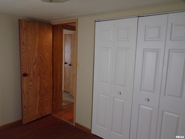 unfurnished bedroom with a closet and dark hardwood / wood-style floors