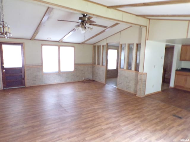 unfurnished living room featuring lofted ceiling with beams, ceiling fan with notable chandelier, and light wood-type flooring