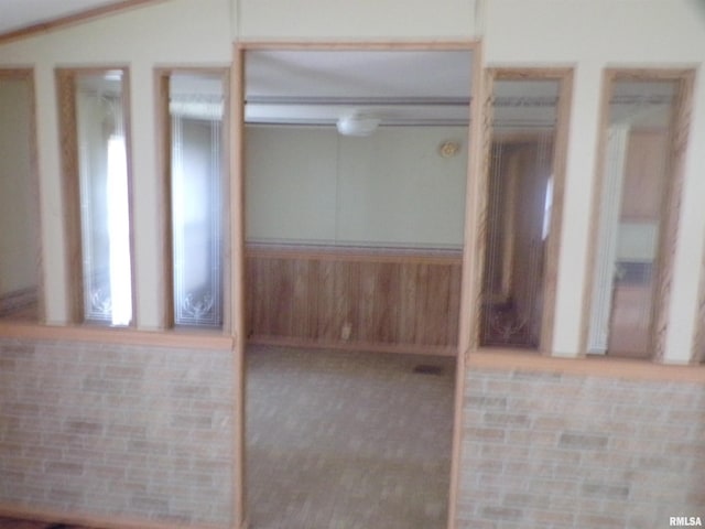 carpeted spare room featuring vaulted ceiling