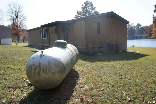 view of property exterior with a water view, cooling unit, and a yard