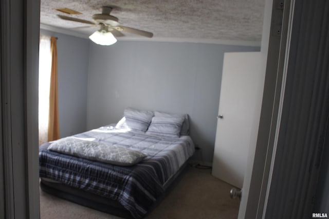 bedroom with a textured ceiling, carpet, and ceiling fan