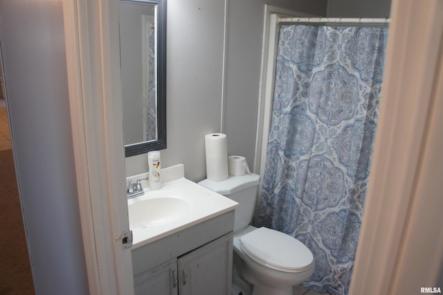 bathroom featuring vanity, curtained shower, and toilet