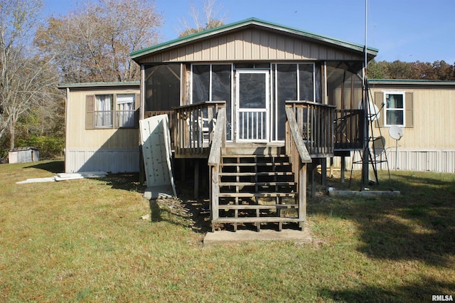 rear view of house with a yard and a sunroom