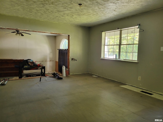 empty room featuring a textured ceiling and ceiling fan