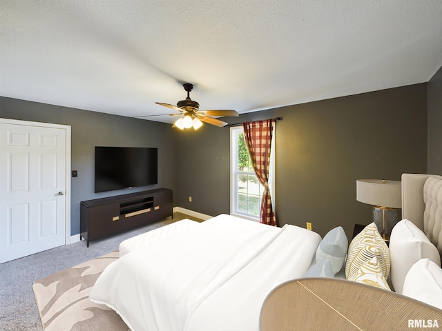 carpeted bedroom with ceiling fan and a textured ceiling