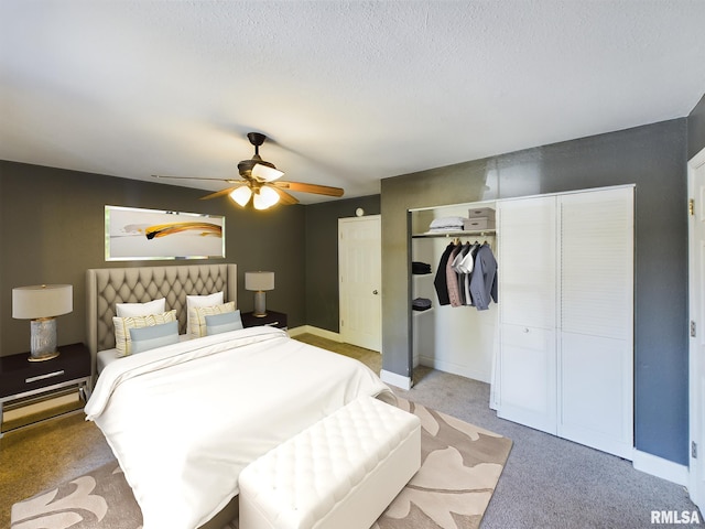 bedroom featuring a textured ceiling, light colored carpet, and ceiling fan