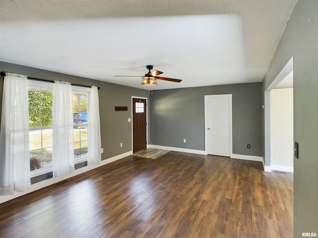 interior space featuring a textured ceiling, dark wood-type flooring, and ceiling fan