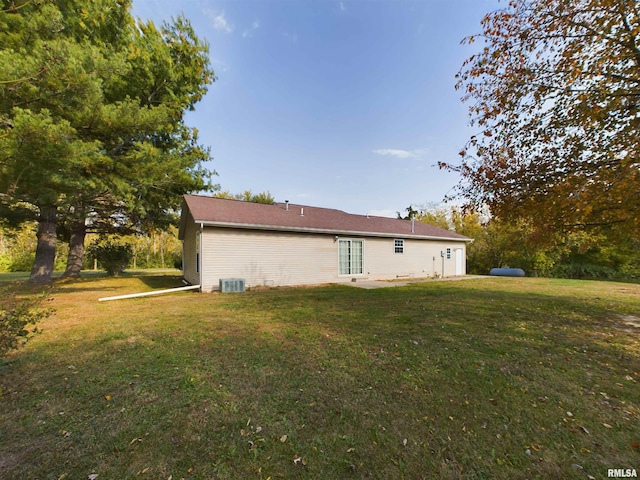 back of property featuring central air condition unit and a lawn