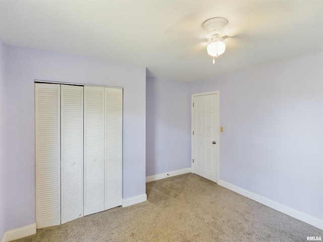 unfurnished bedroom with a closet, ceiling fan, and light carpet