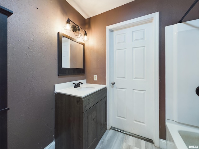 bathroom featuring vanity, hardwood / wood-style flooring, and bathtub / shower combination