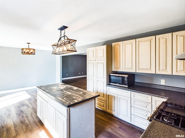 kitchen featuring dark hardwood / wood-style flooring, a center island, black range oven, and pendant lighting