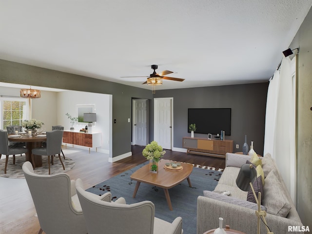 living room with hardwood / wood-style flooring and ceiling fan with notable chandelier