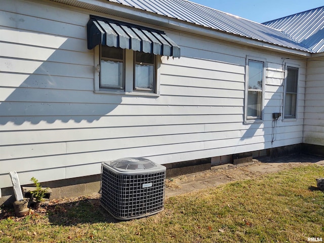 view of side of property with central air condition unit and a yard