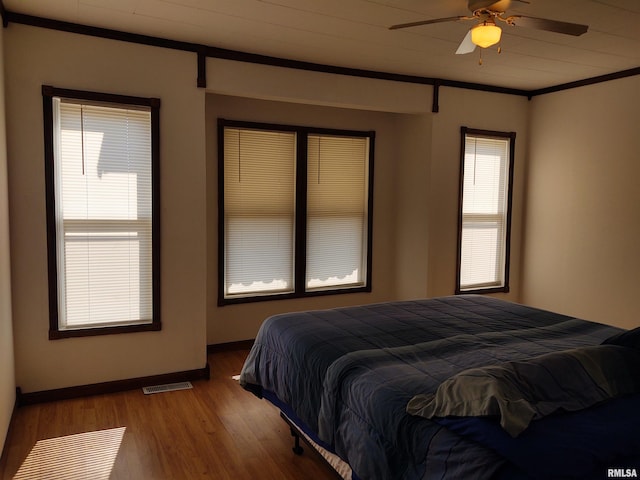 bedroom with ornamental molding, hardwood / wood-style flooring, and ceiling fan