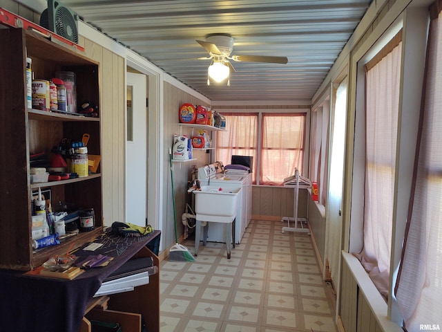 interior space with wooden walls, washing machine and dryer, and ceiling fan