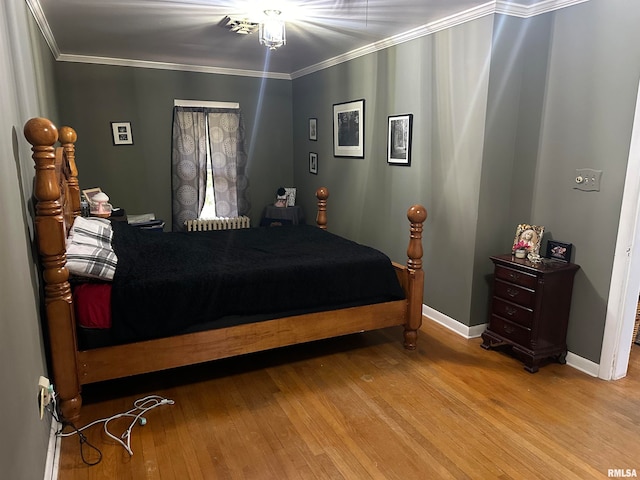 bedroom featuring ornamental molding and light hardwood / wood-style floors