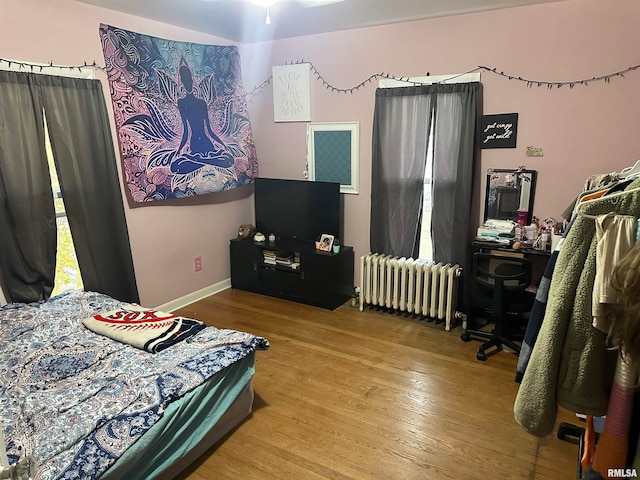 bedroom with hardwood / wood-style flooring and radiator