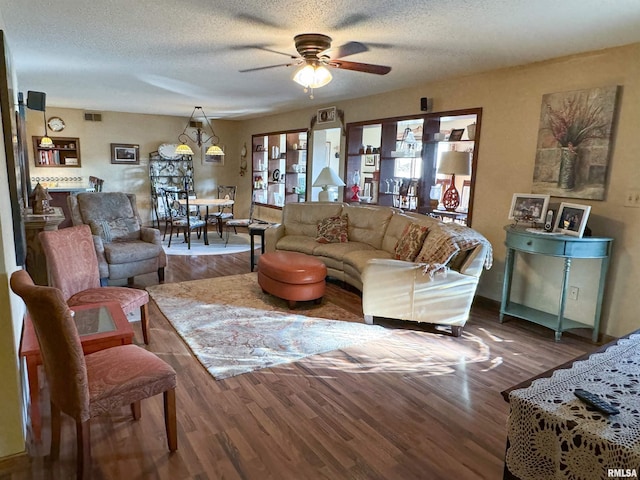 living room featuring a textured ceiling, hardwood / wood-style flooring, and ceiling fan