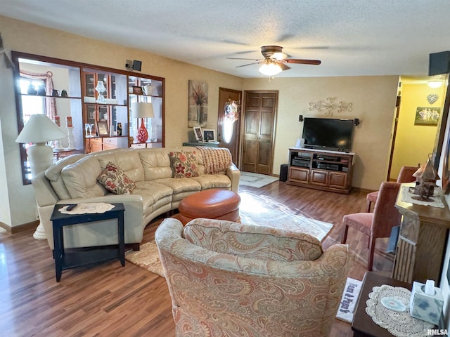 living room with hardwood / wood-style floors, a textured ceiling, and ceiling fan