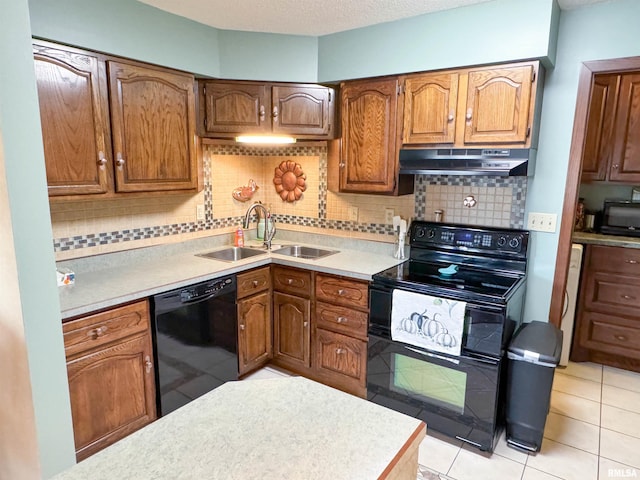 kitchen featuring tasteful backsplash, black appliances, sink, a textured ceiling, and light tile patterned floors