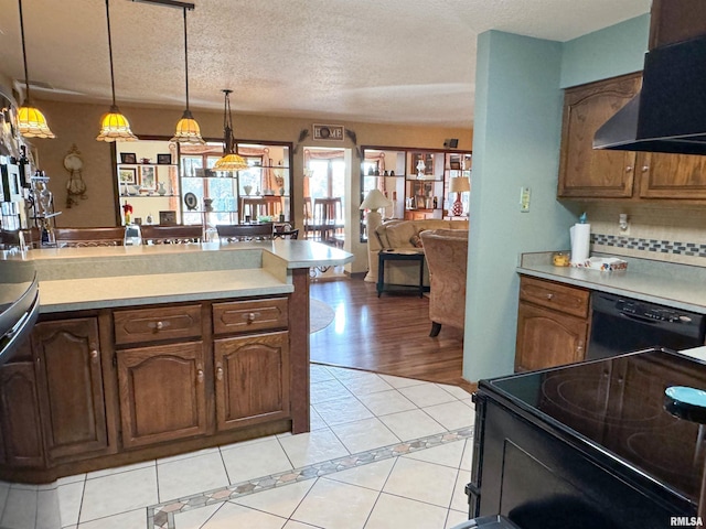 kitchen with tasteful backsplash, black appliances, a textured ceiling, hanging light fixtures, and light tile patterned floors