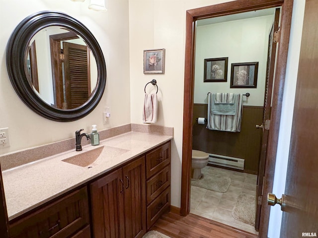 bathroom featuring vanity, a baseboard heating unit, wood-type flooring, and toilet