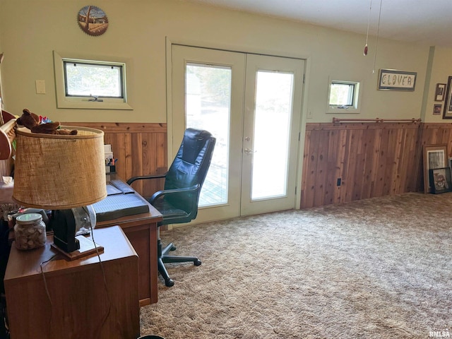 office space with french doors, carpet, and wooden walls