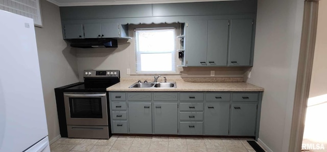 kitchen featuring gray cabinetry, sink, white fridge, and stainless steel range with electric stovetop