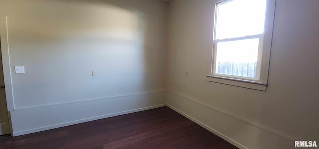 unfurnished room with dark wood-type flooring