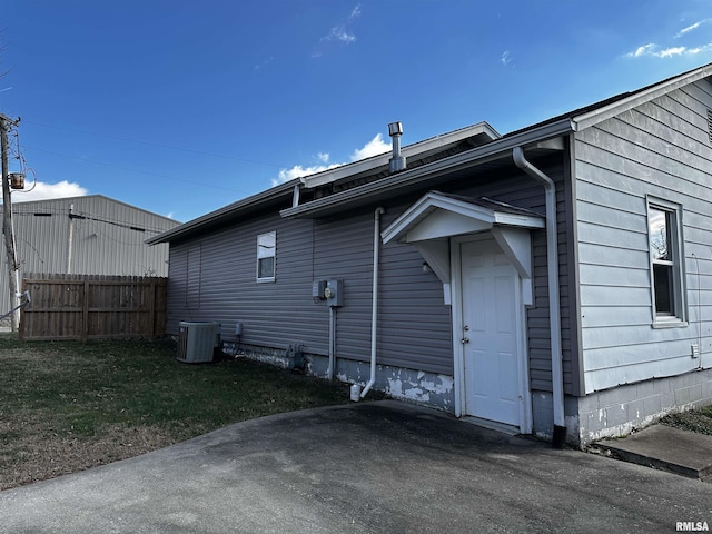 rear view of house featuring a lawn and central AC