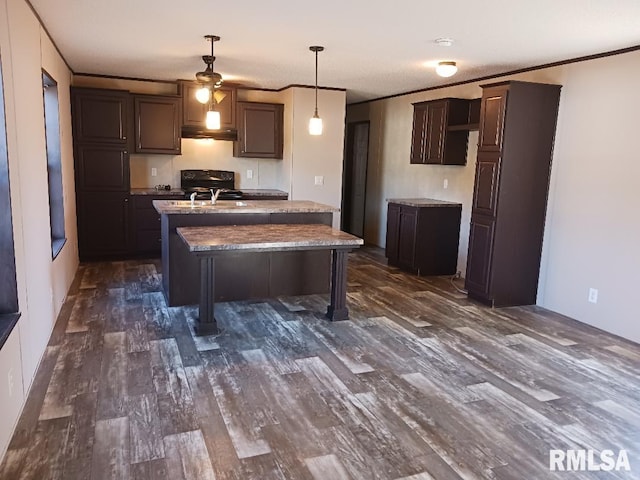 kitchen with dark brown cabinetry, hanging light fixtures, and dark hardwood / wood-style flooring