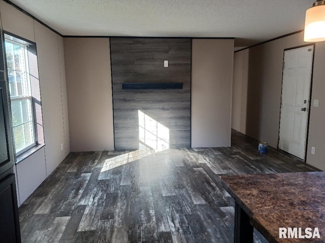 unfurnished room with a textured ceiling and dark hardwood / wood-style floors