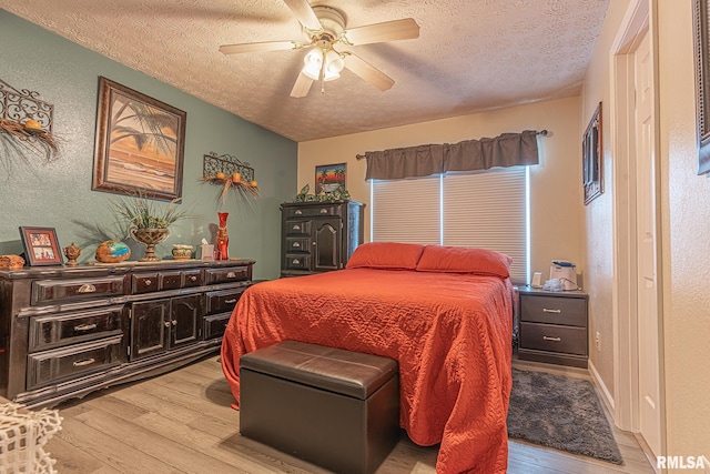 bedroom featuring a textured ceiling, light wood-type flooring, and ceiling fan