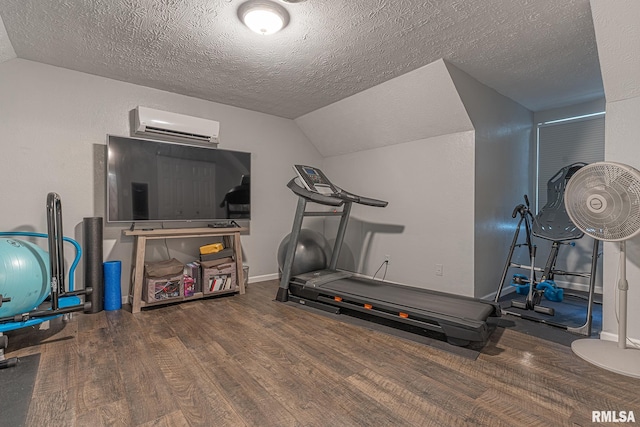 workout area with a textured ceiling, vaulted ceiling, a wall mounted air conditioner, and dark hardwood / wood-style floors