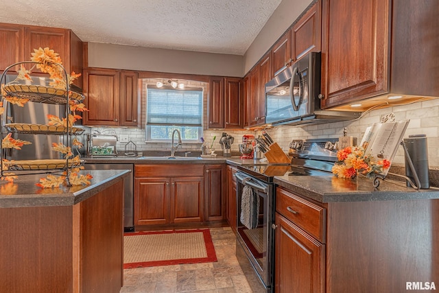 kitchen with appliances with stainless steel finishes, decorative backsplash, a textured ceiling, and sink