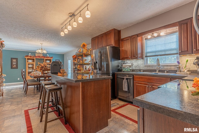 kitchen with stainless steel appliances, tasteful backsplash, sink, and a textured ceiling