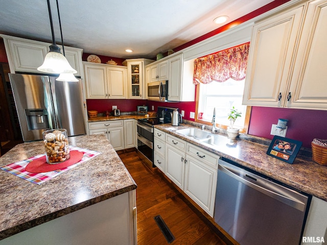 kitchen with sink, stainless steel appliances, decorative light fixtures, white cabinets, and dark hardwood / wood-style floors