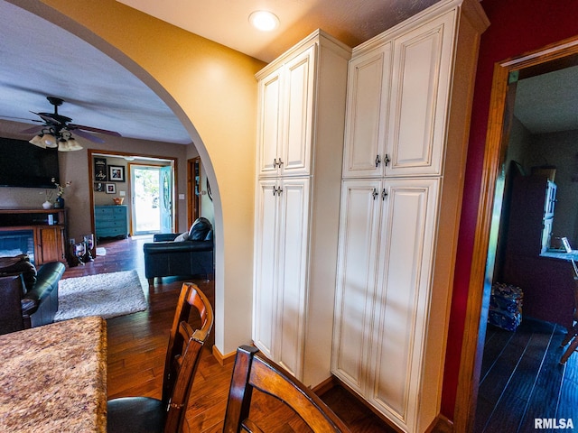 kitchen featuring light stone counters, dark hardwood / wood-style flooring, and ceiling fan