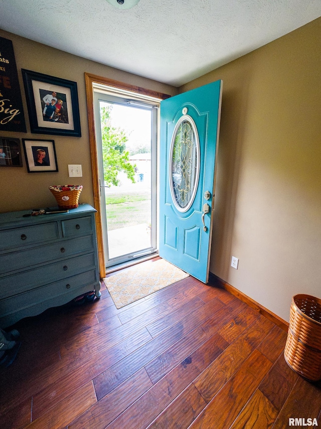 entryway featuring dark wood-type flooring and a textured ceiling