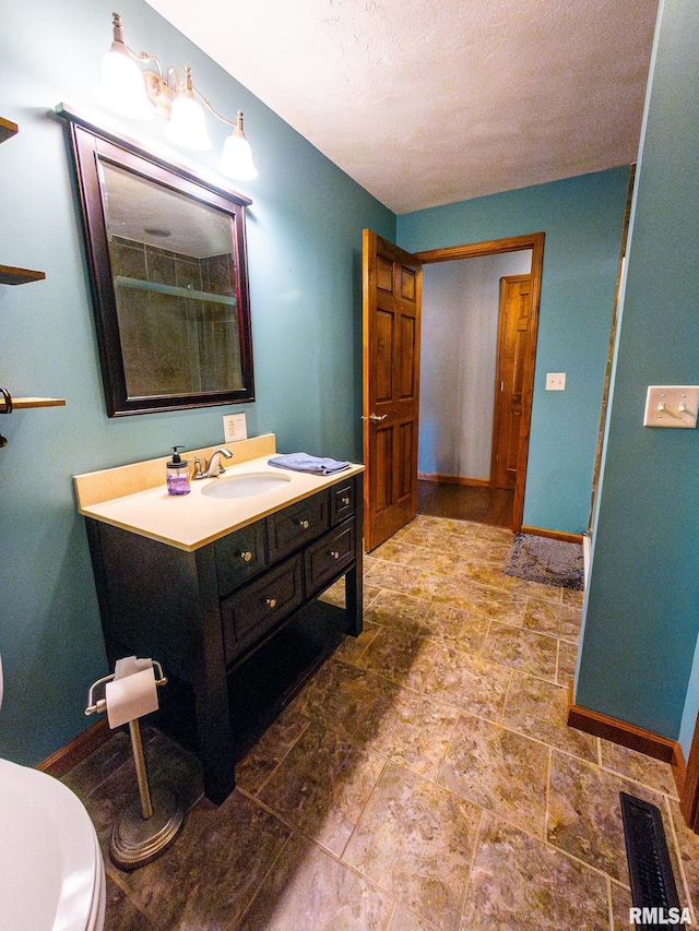 bathroom featuring vanity, toilet, and an enclosed shower