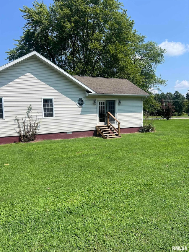 rear view of house featuring a lawn