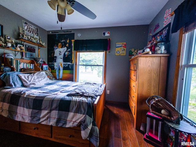 bedroom featuring multiple windows, dark wood-type flooring, and ceiling fan