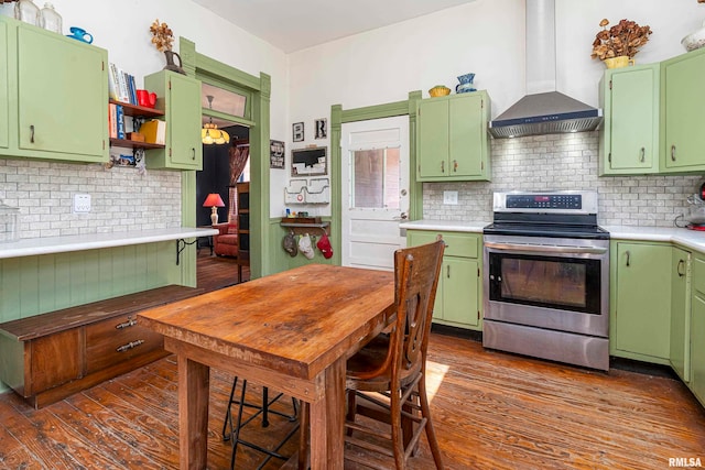 kitchen featuring electric stove, wall chimney exhaust hood, and green cabinetry