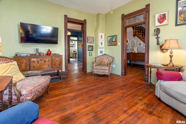 living room with a textured ceiling and dark hardwood / wood-style flooring