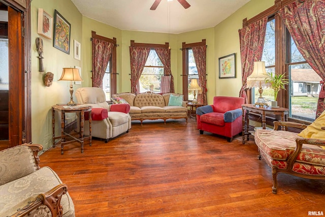 living room featuring wood-type flooring and ceiling fan